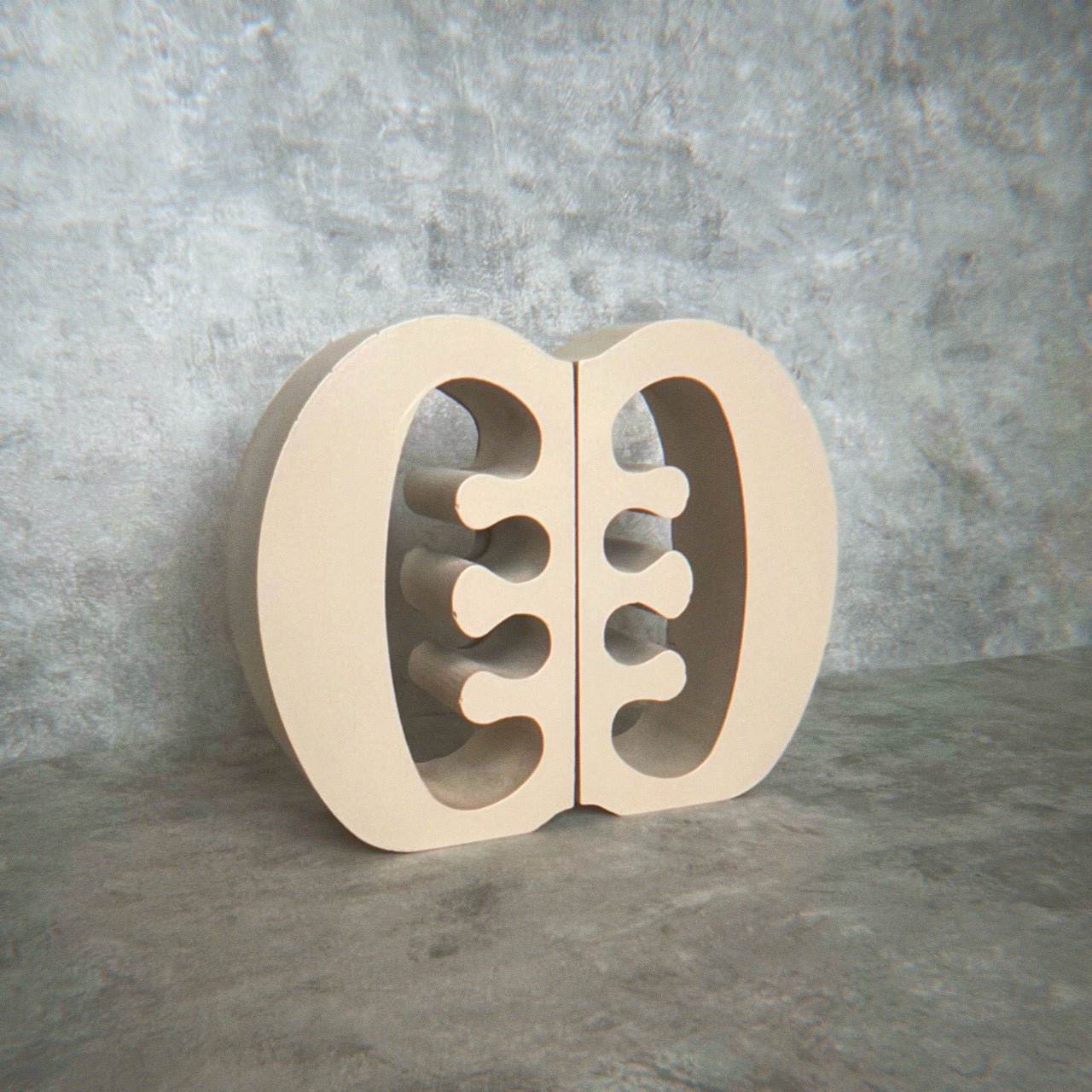 Decorative warm beige Ese Ne Tekrema adinkra bookends on a light gray lime wash background.