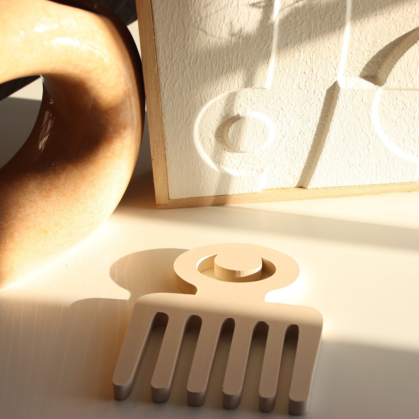 cream Duafe adinkra coaster on white background.