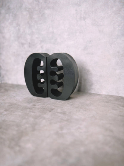 Decorative black Ese Ne Tekrema adinkra bookends on a light gray lime wash background.