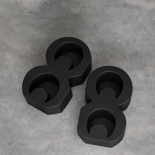 Black Adinkra bookends laying on grey limewash background 